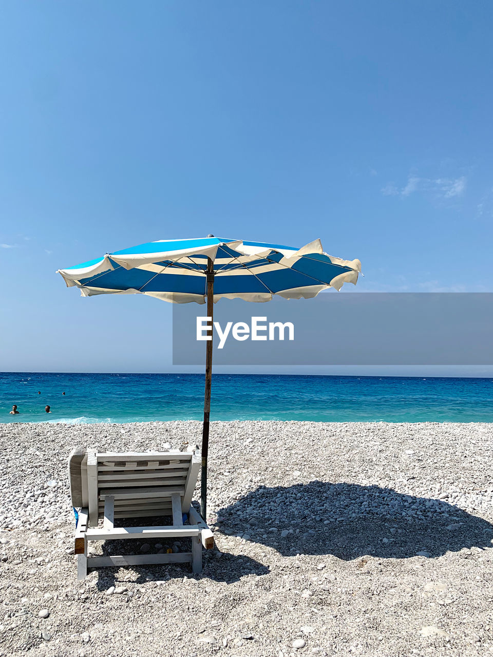 Deck chairs on beach against blue sky