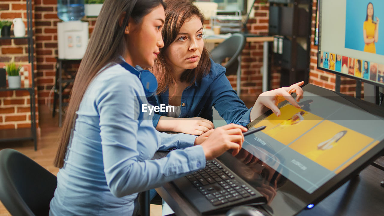 portrait of young woman using laptop while sitting on table