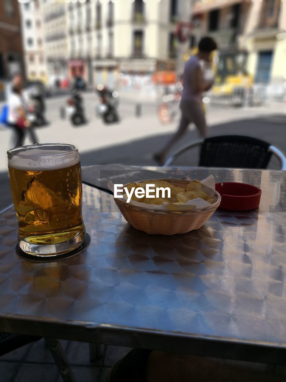 Close-up of beer glass and potato chips on table at restaurant