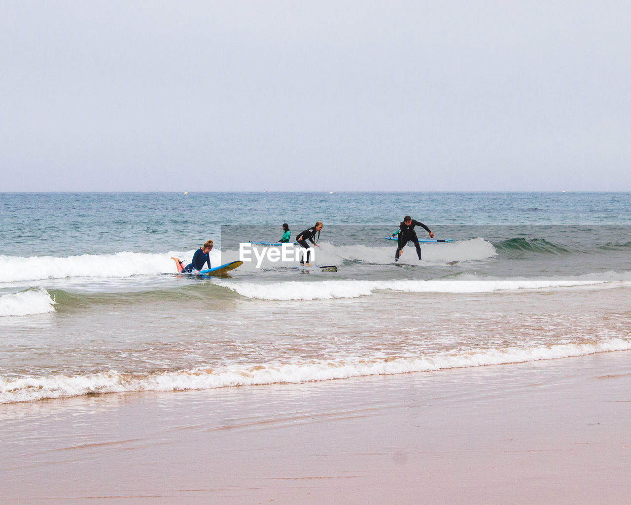 PEOPLE ENJOYING ON BEACH AGAINST SKY