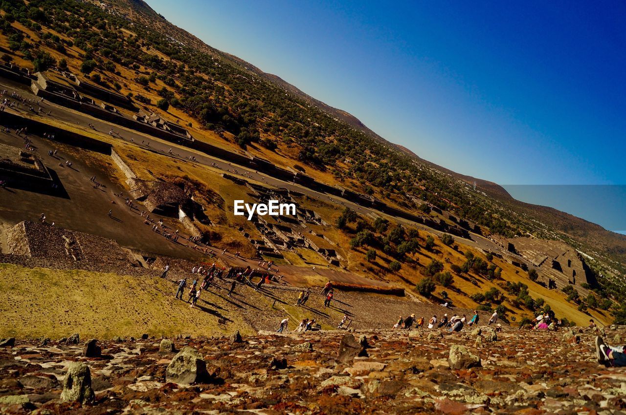 PEOPLE ON MOUNTAINS AGAINST CLEAR SKY