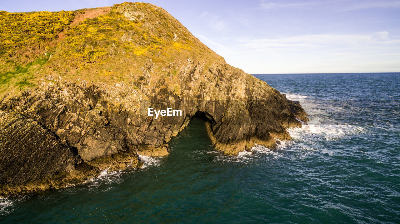 ROCK FORMATIONS IN SEA AGAINST SKY