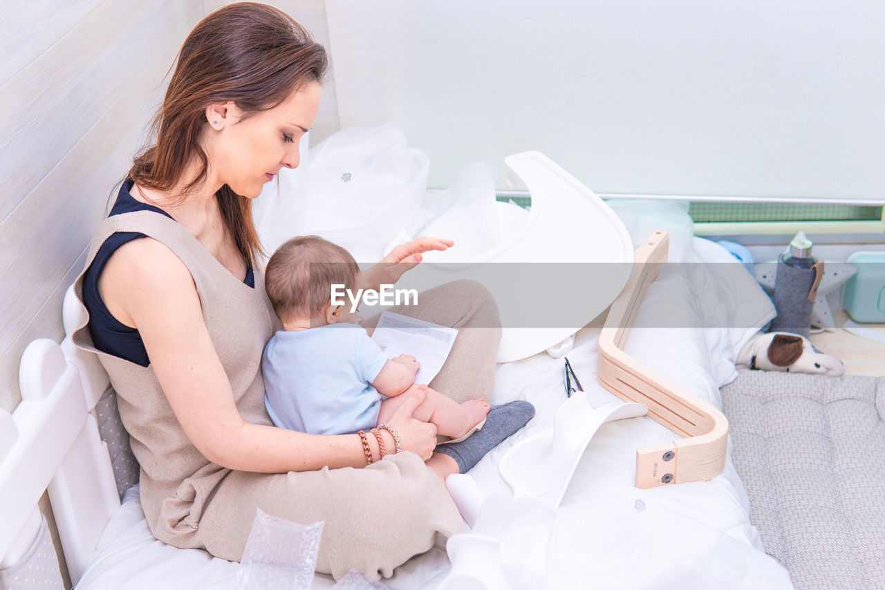 Mother and son sitting on bed