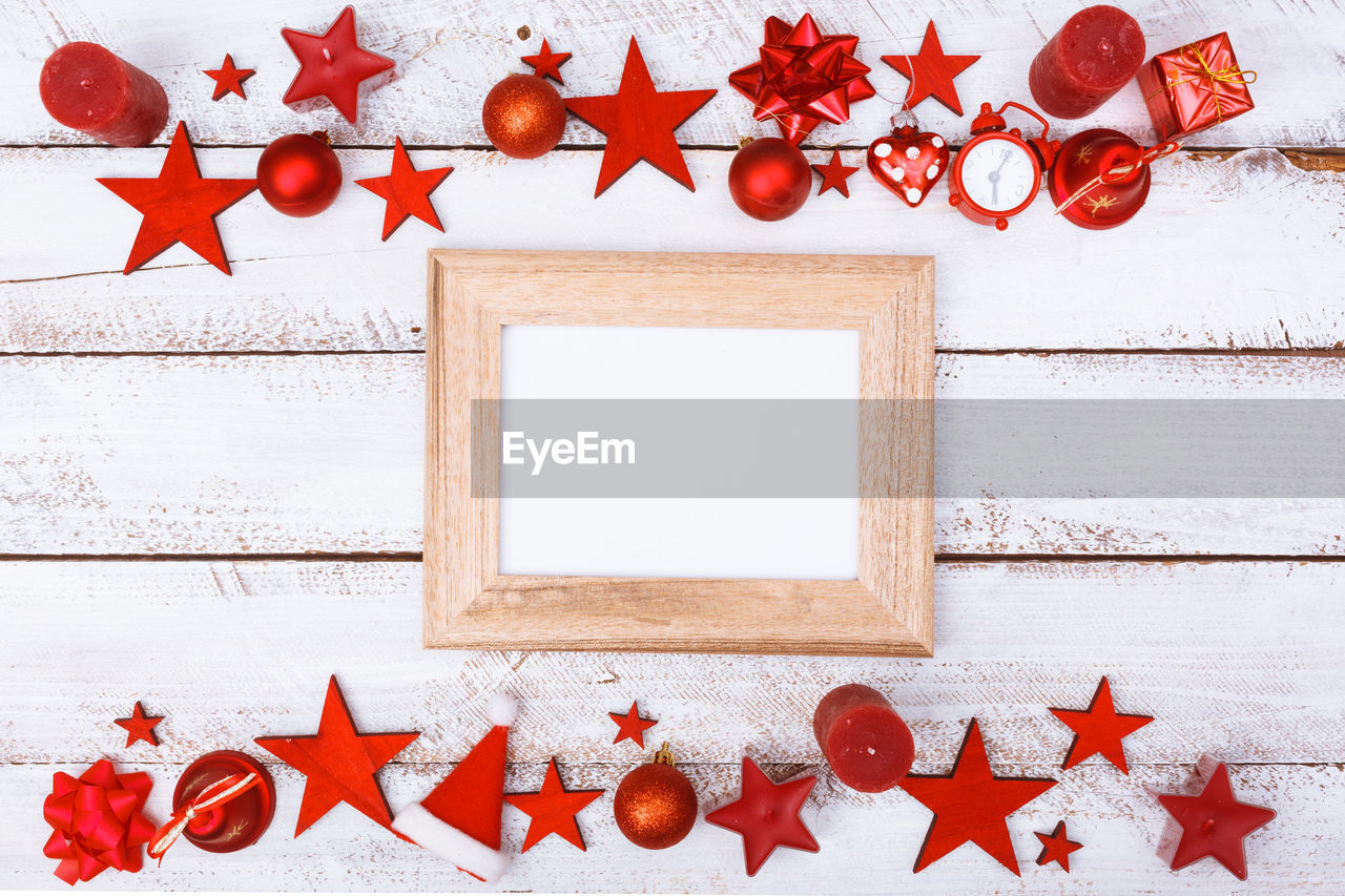 Directly above shot of christmas decorations with blank frame on table