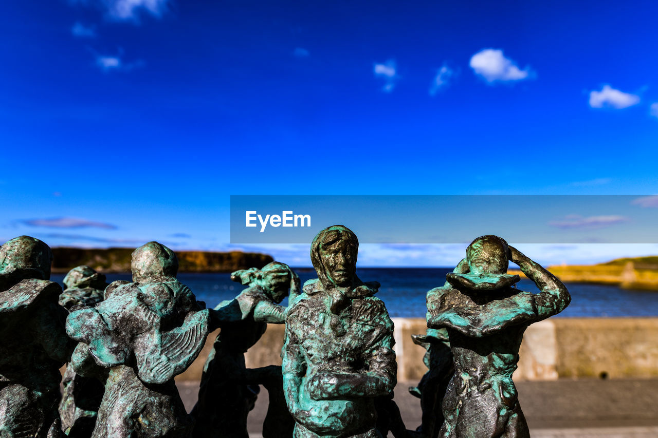 STATUE AGAINST BLUE SKY AND TREES