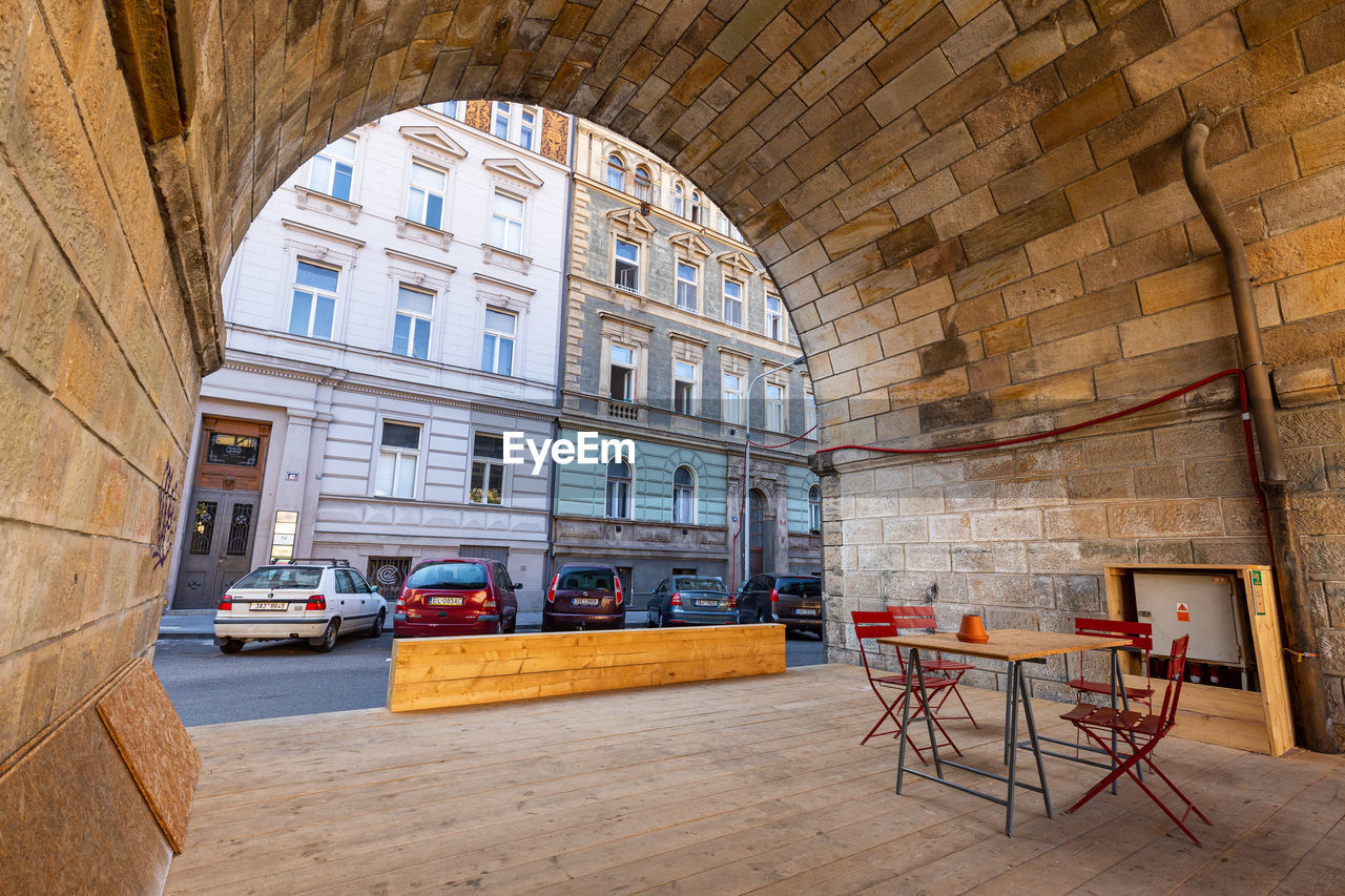 CHAIRS AND TABLE IN CAFE BY BUILDING