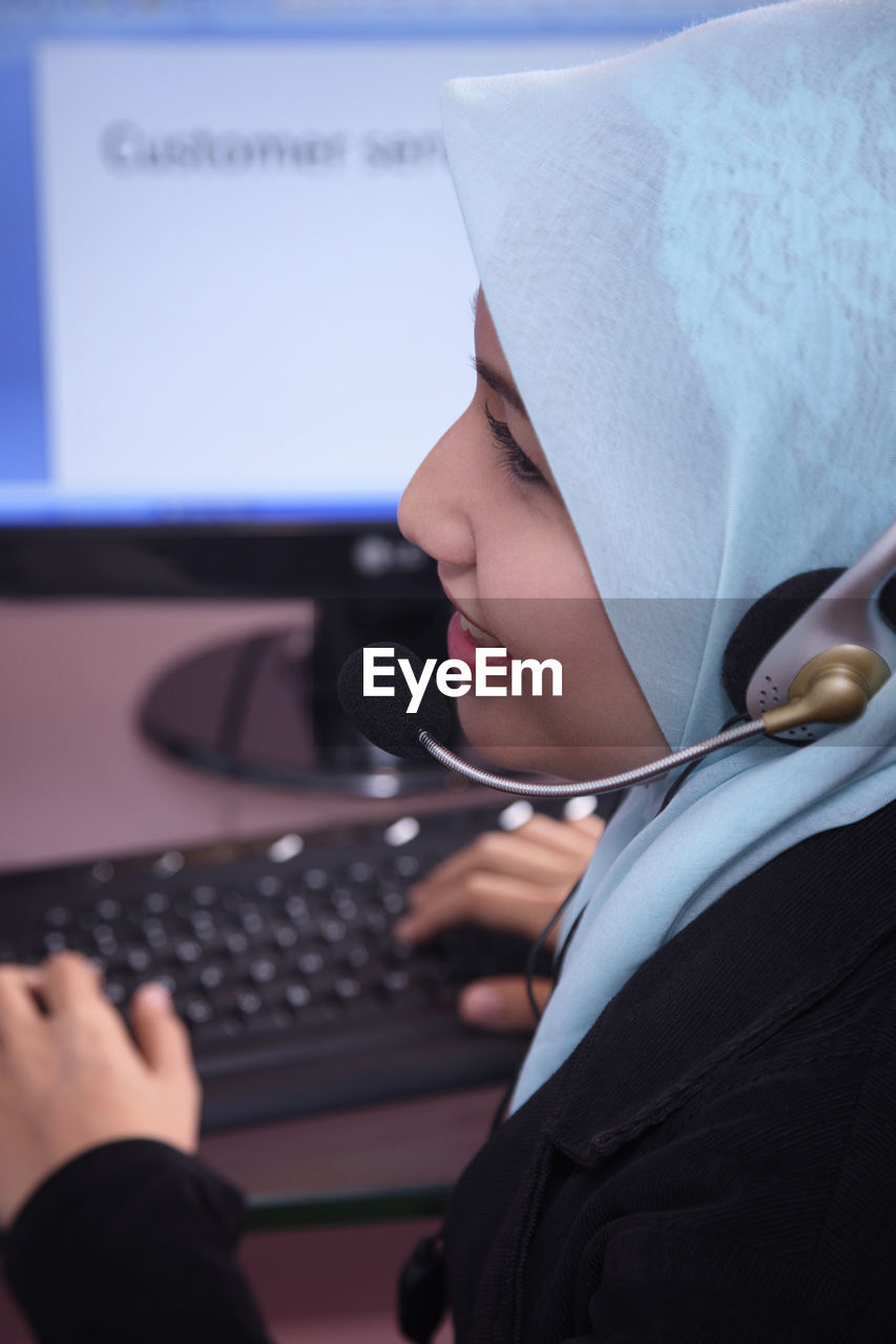 Female customer service representative using computer in office