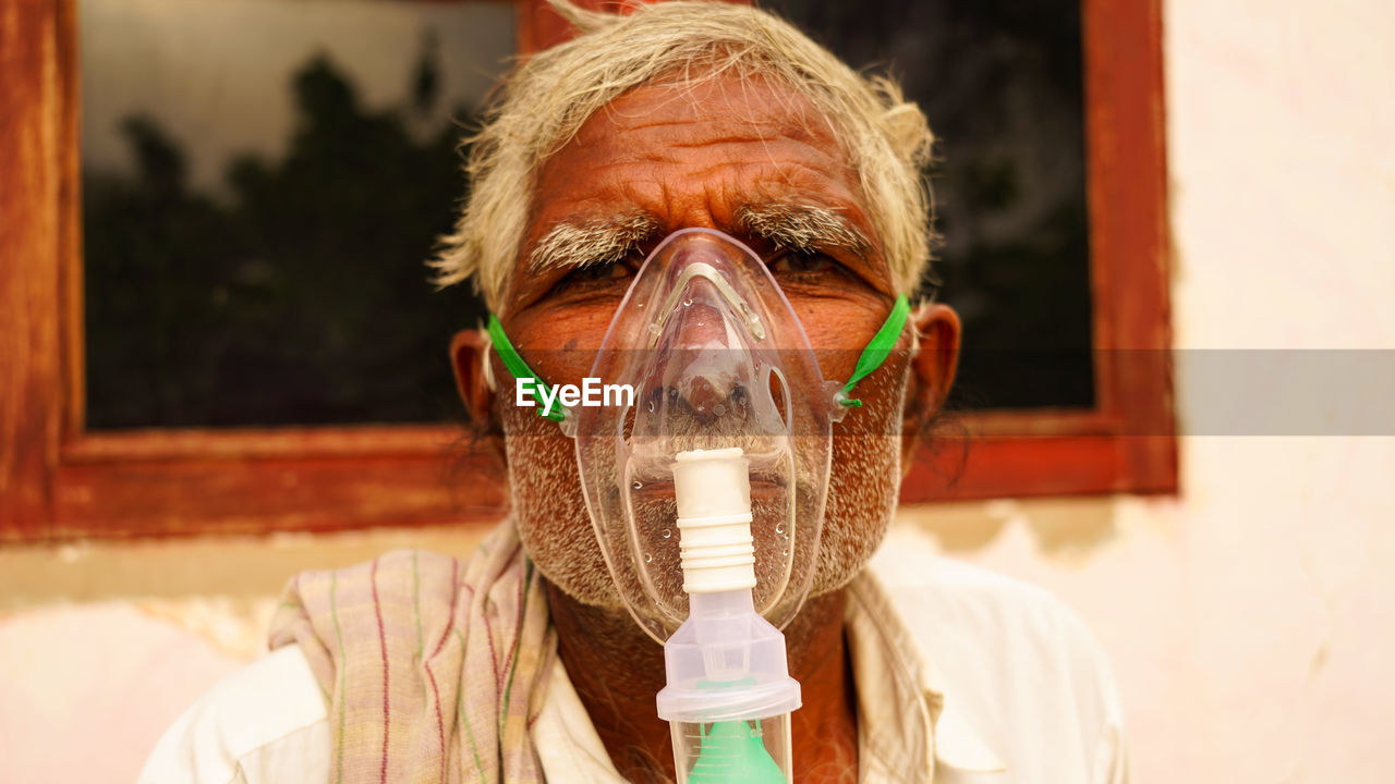 Elder person infected with covid 19 disease. patient inhaling oxygen wearing mask with liquid oxygen