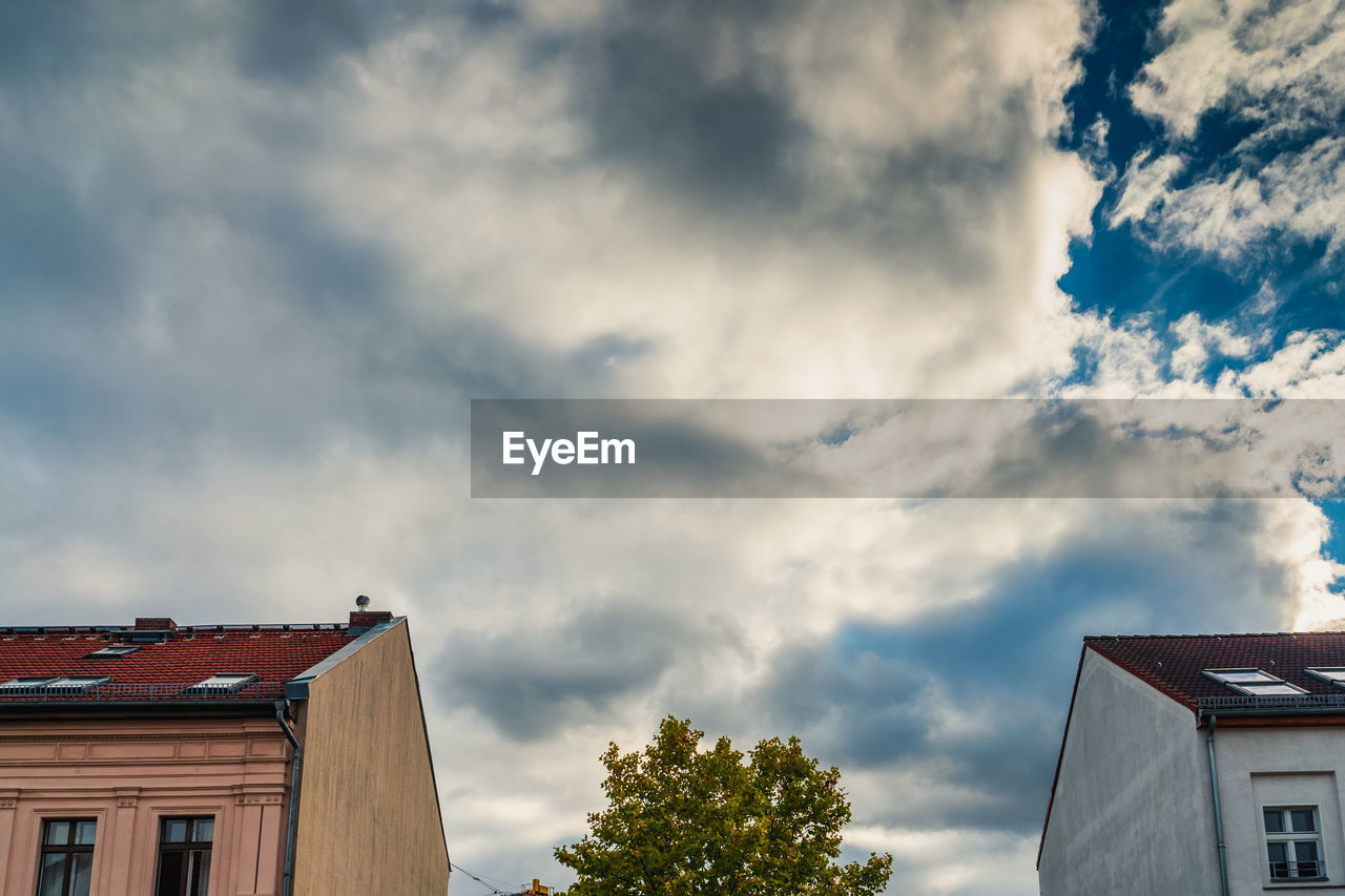 Low angle view of buildings against cloudy sky