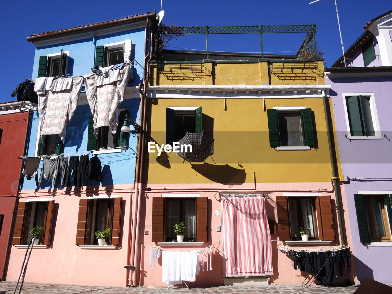 LOW ANGLE VIEW OF CLOTHES DRYING OUTSIDE BUILDING