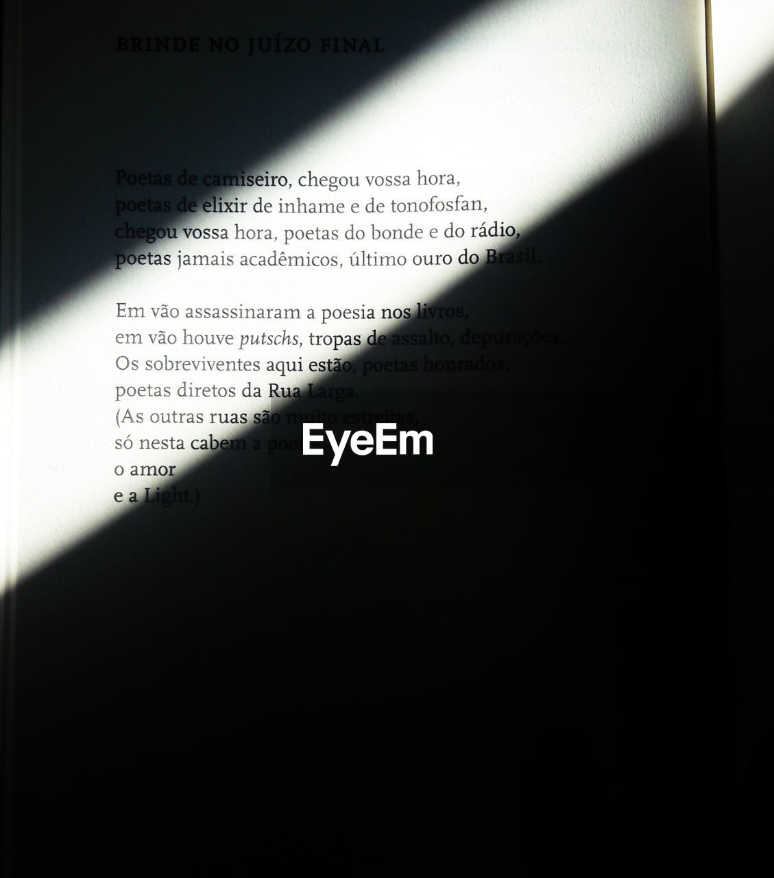 HIGH ANGLE VIEW OF TEXT ON BOOK AGAINST BLACK BACKGROUND