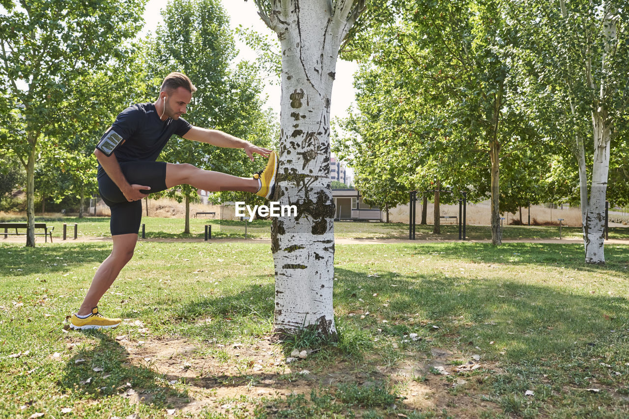 Man stretching after exercise in a park.