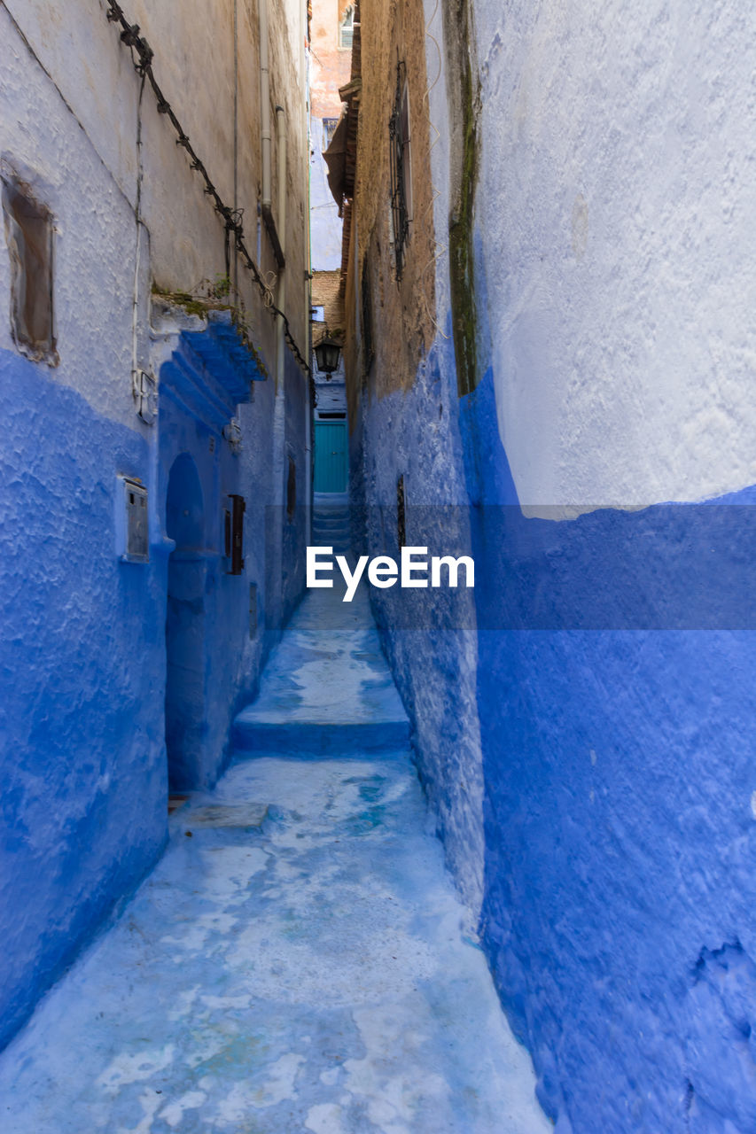 NARROW ALLEY AMIDST BUILDINGS IN WINTER