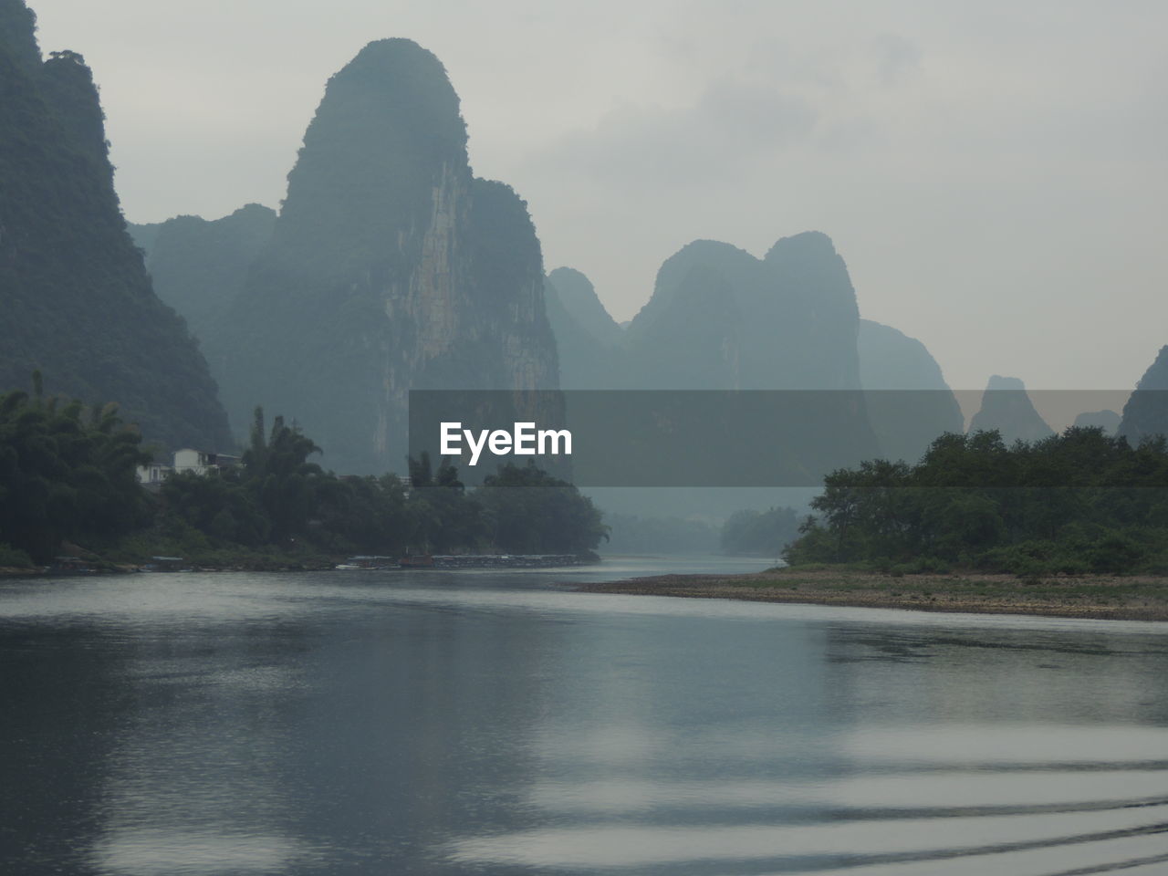 Scenic view of river and mountains against sky