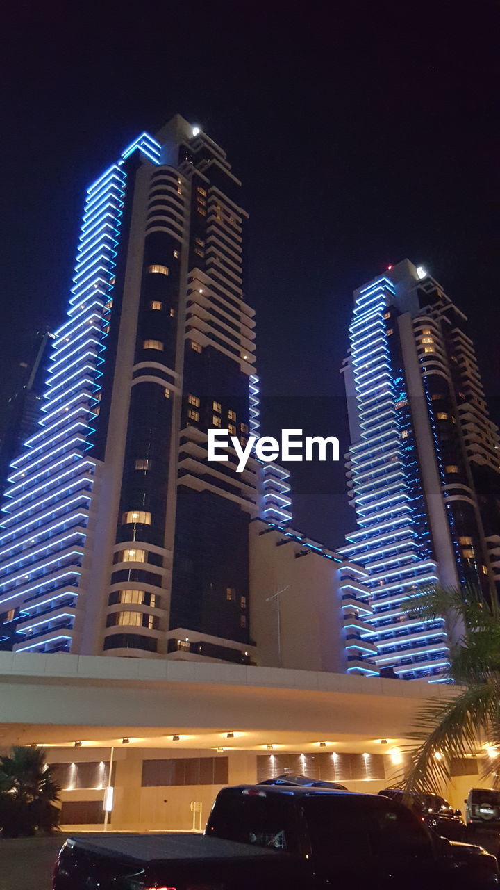 LOW ANGLE VIEW OF ILLUMINATED SKYSCRAPERS AGAINST SKY