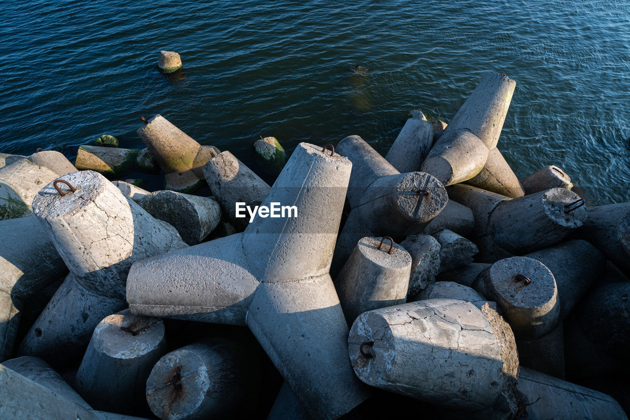 HIGH ANGLE VIEW OF PEBBLES ON ROCKS AT BEACH