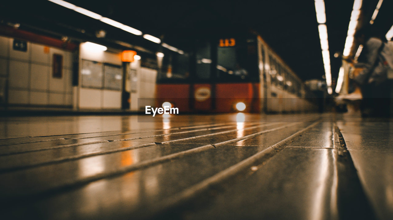 Surface level of train at railroad station platform at night