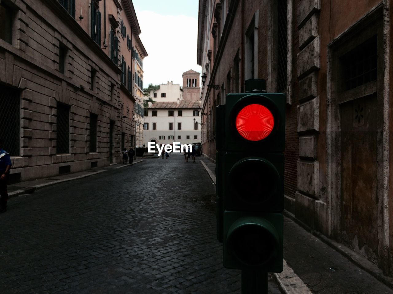 Traffic signal on road amidst buildings