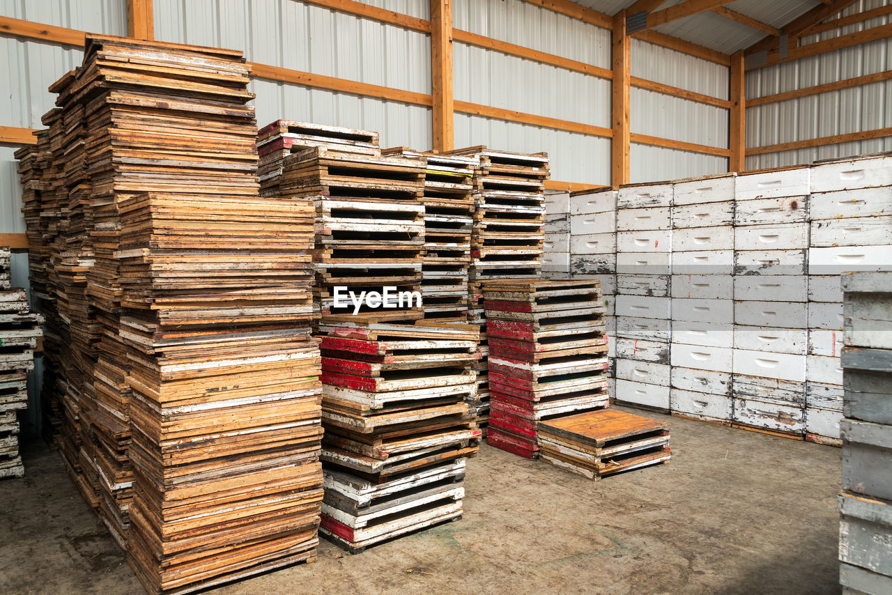 Stack of wooden pallets by beehives in storage room