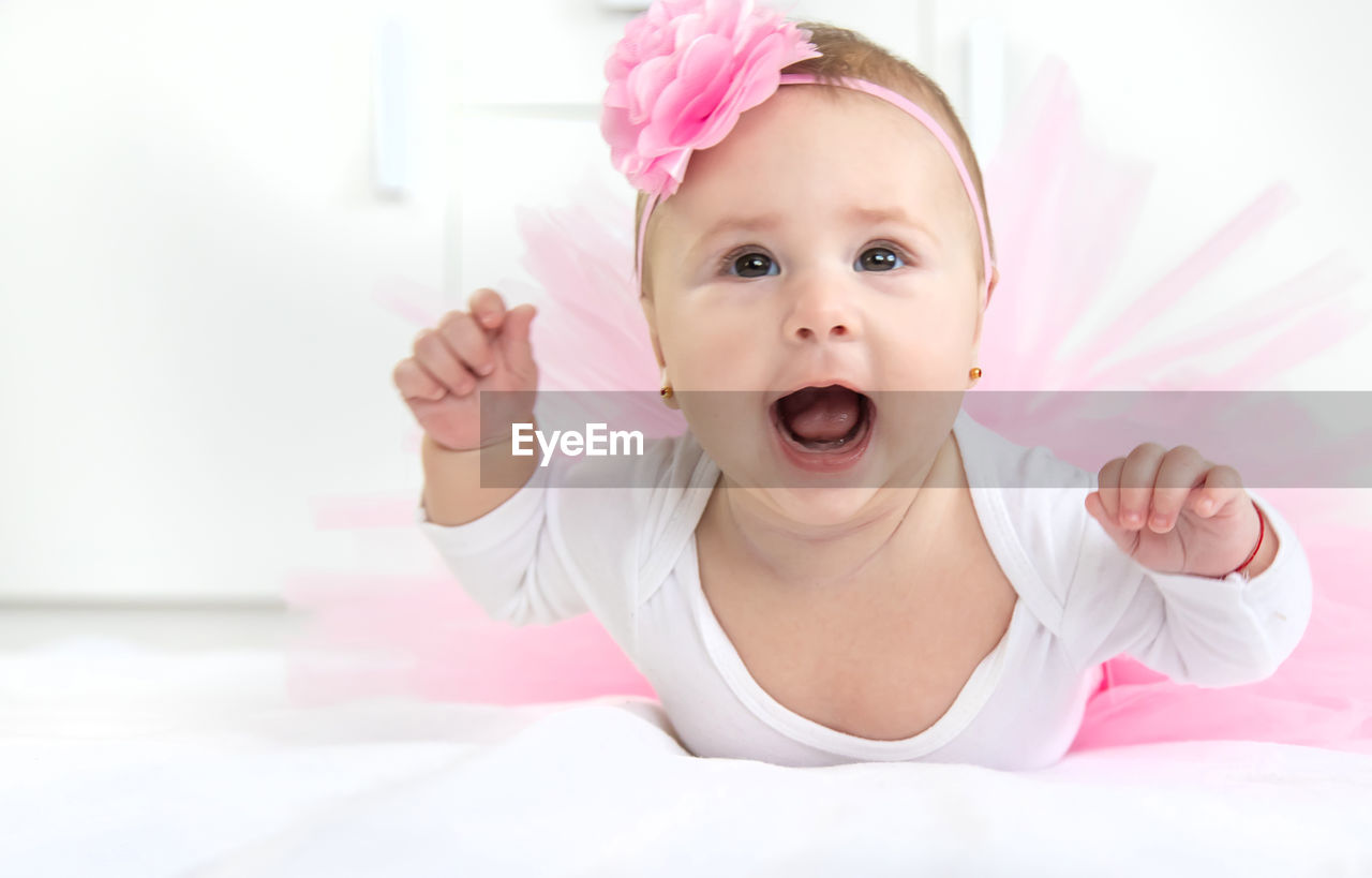 Cute baby girl on bed at home