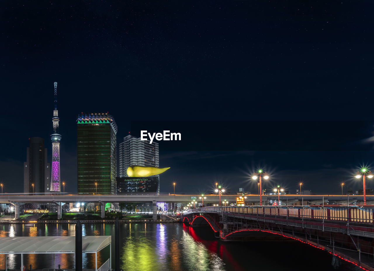 Azuma bridge on sumida river leading to the golden flame  of the asahi beer building at night