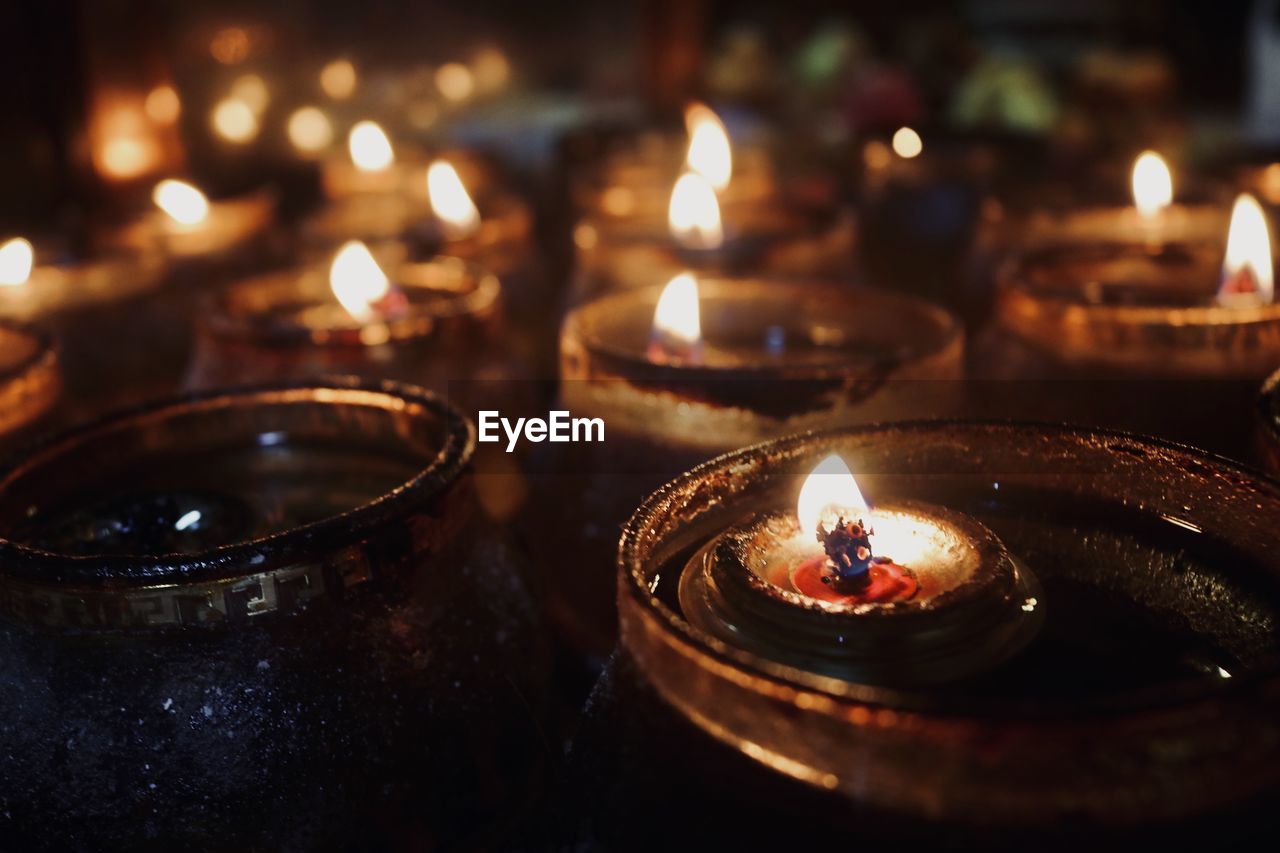 Close-up of lit tea light candles in temple