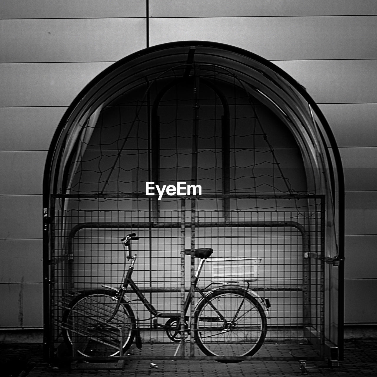 BICYCLE PARKED BY BUILDING