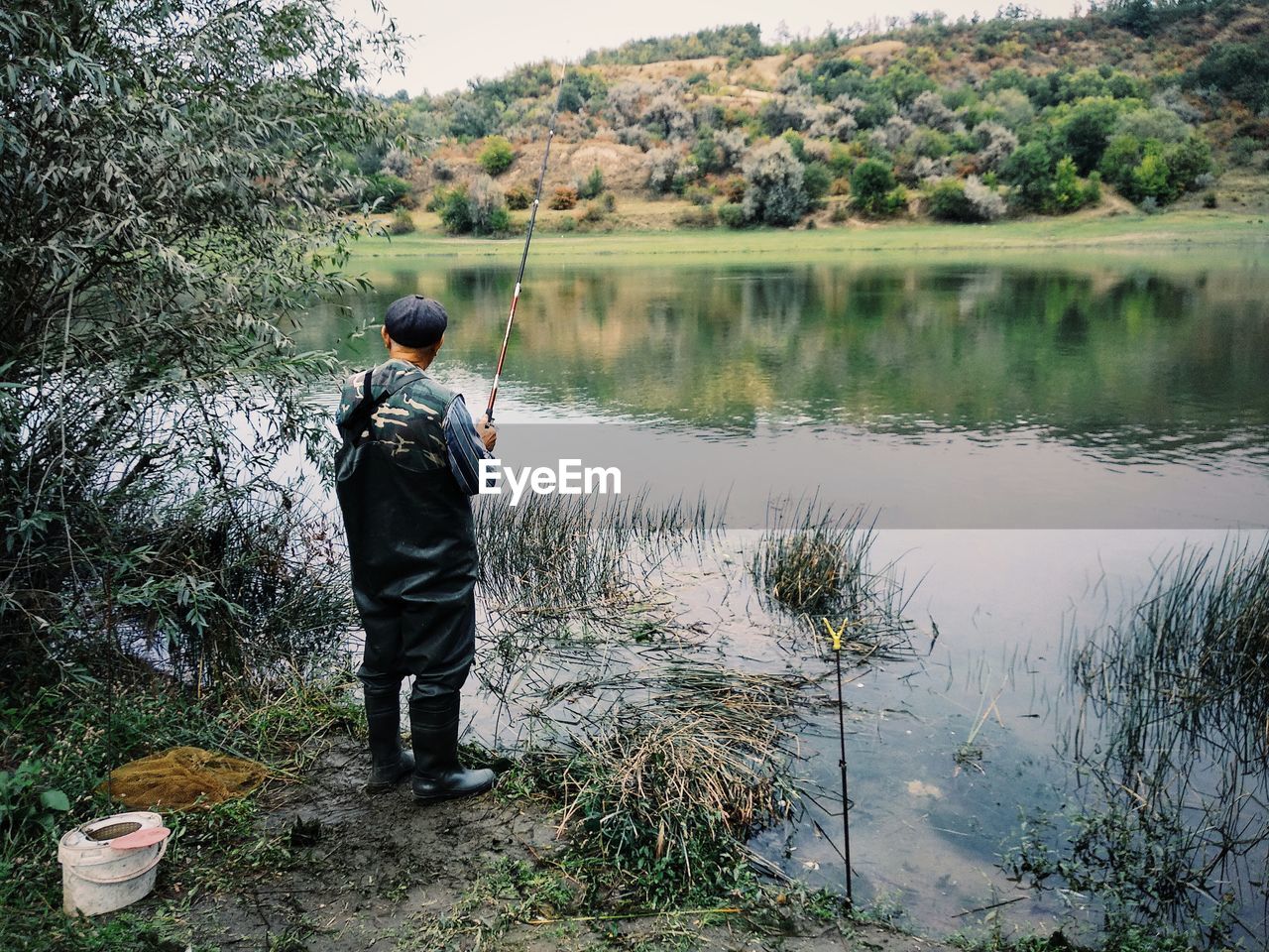 Rear view of man fishing at lake