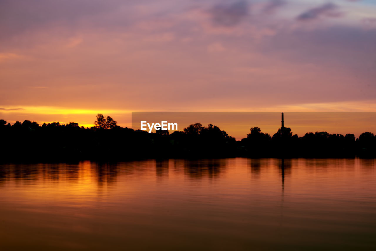 Scenic view of lake against orange sky