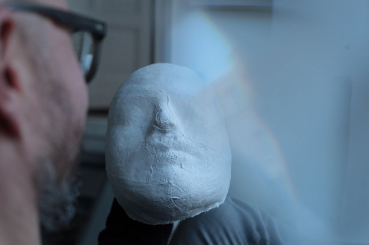 Cropped image of man making mask at home