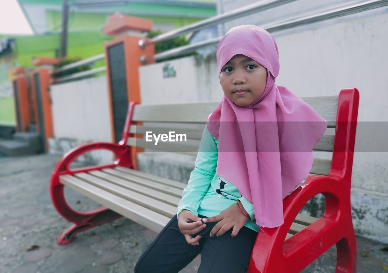 A girl is sitting on a park bench