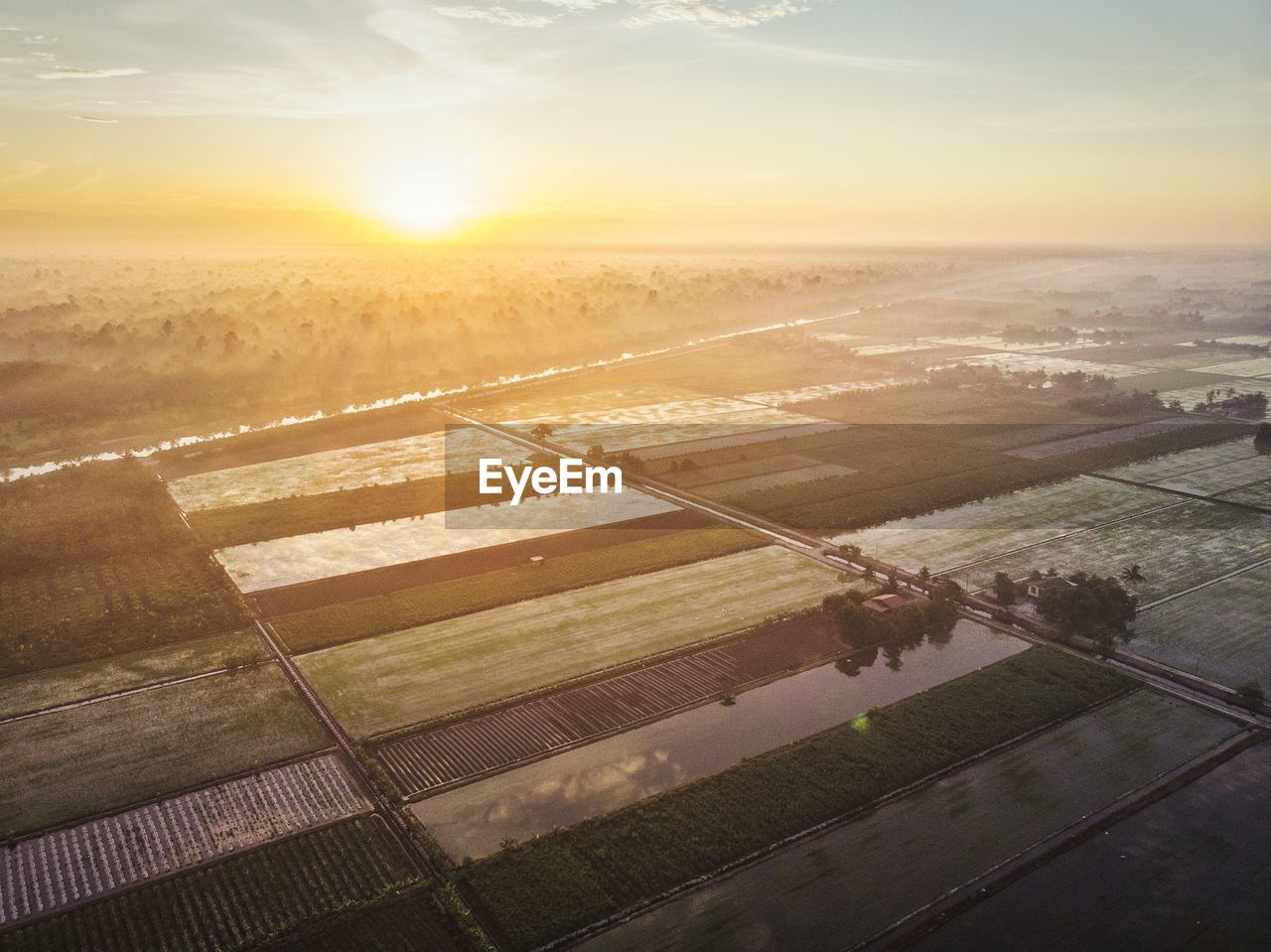 HIGH ANGLE VIEW OF AGRICULTURAL FIELD AGAINST SKY AT SUNSET