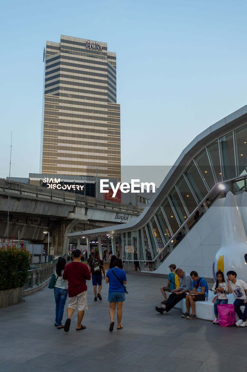 GROUP OF PEOPLE WALKING ON MODERN BUILDING