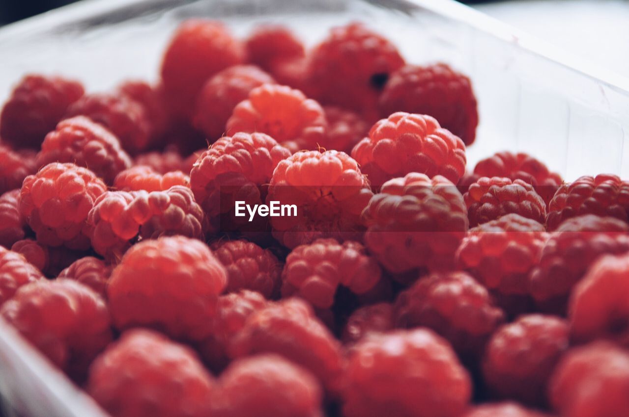 Close-up of fresh juicy raspberries in container