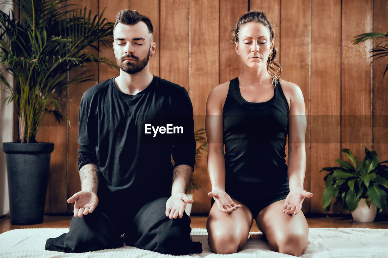 Man doing yoga with woman