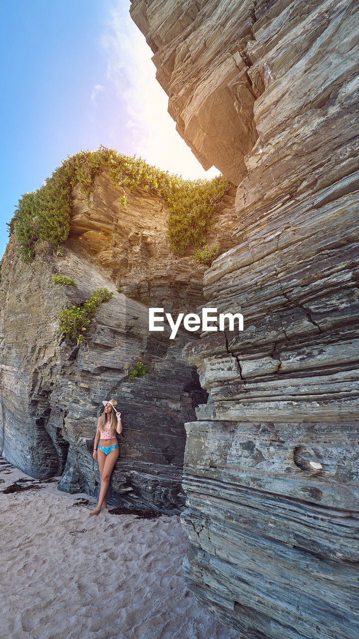 Woman standing against cliff