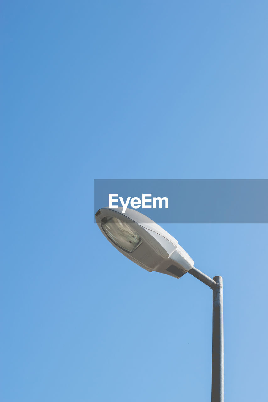 Low angle view of street light against clear blue sky