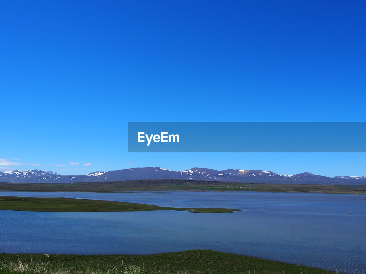 SCENIC VIEW OF LAKE BY MOUNTAINS AGAINST CLEAR BLUE SKY