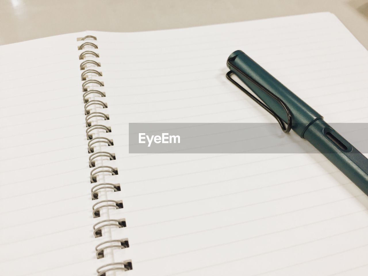 High angle view of pen on spiral notebook