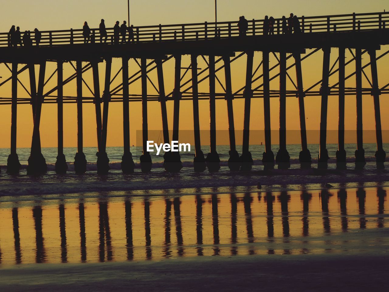 low angle view of silhouette people standing on pier