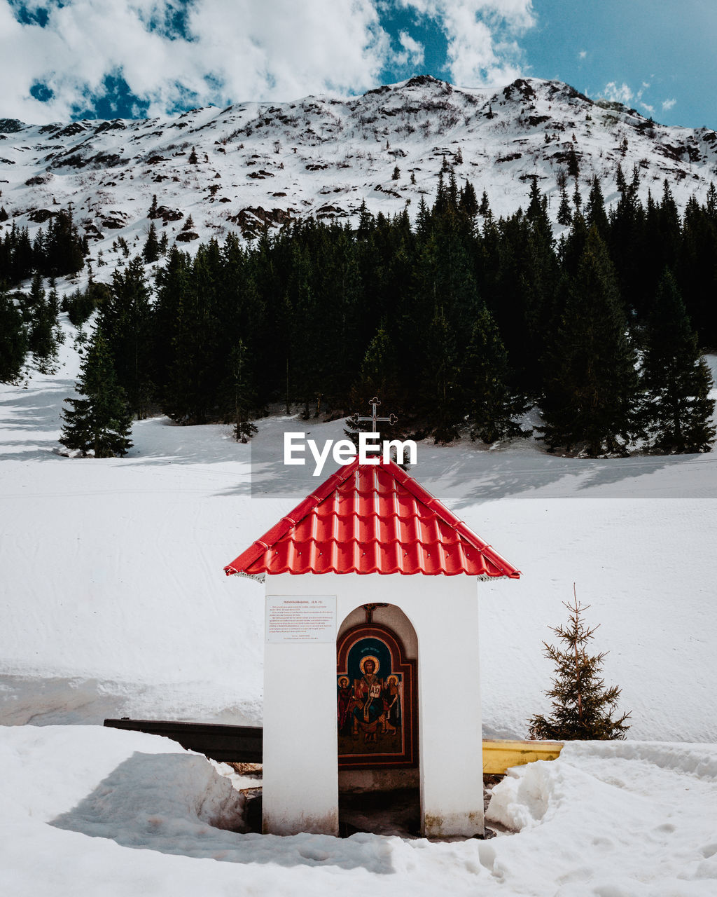 Church on snow covered road against mountain during winter