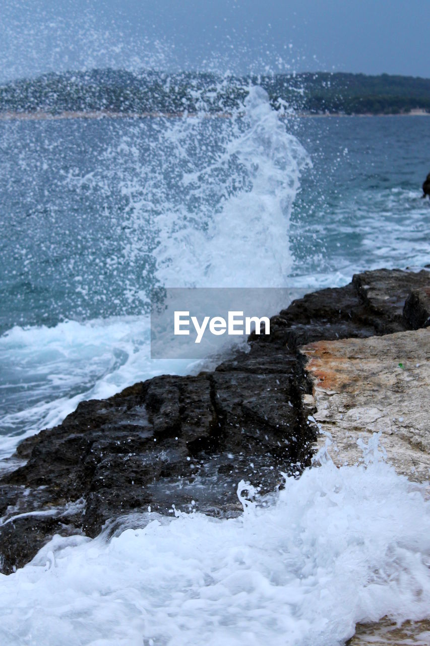 VIEW OF WAVES SPLASHING ON ROCK