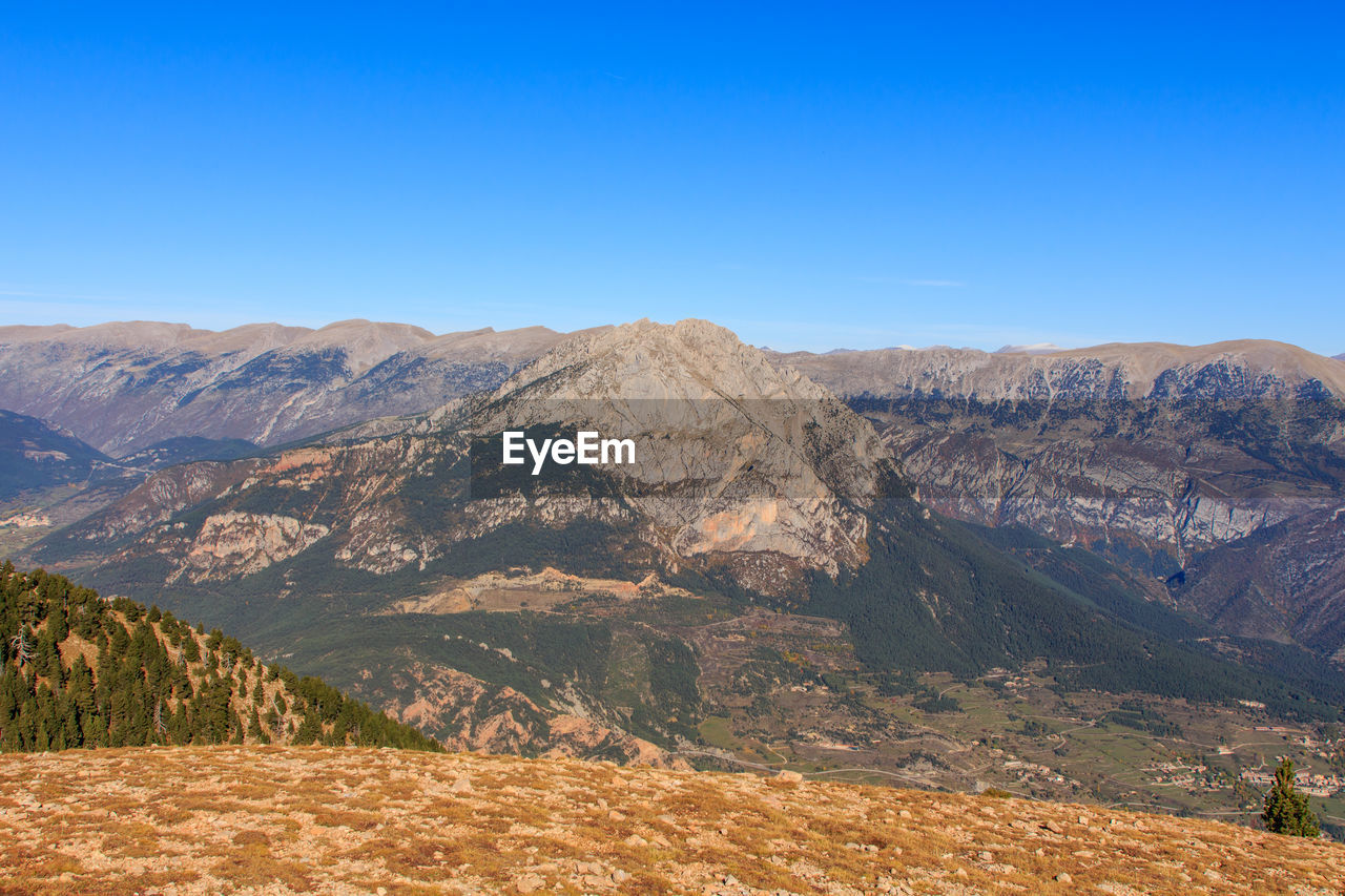 Scenic view of mountains against clear blue sky