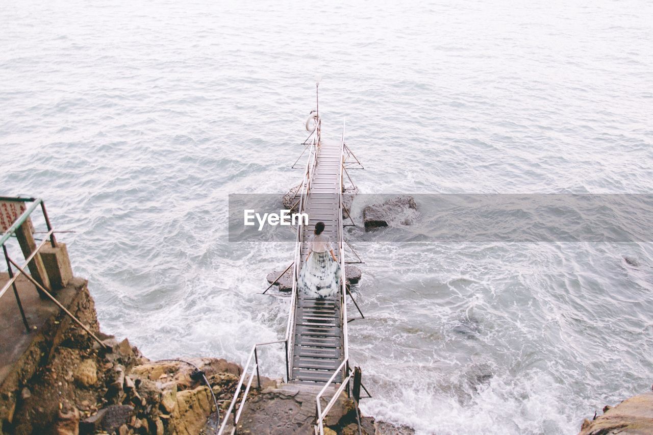 High angle view of woman on pier over sea