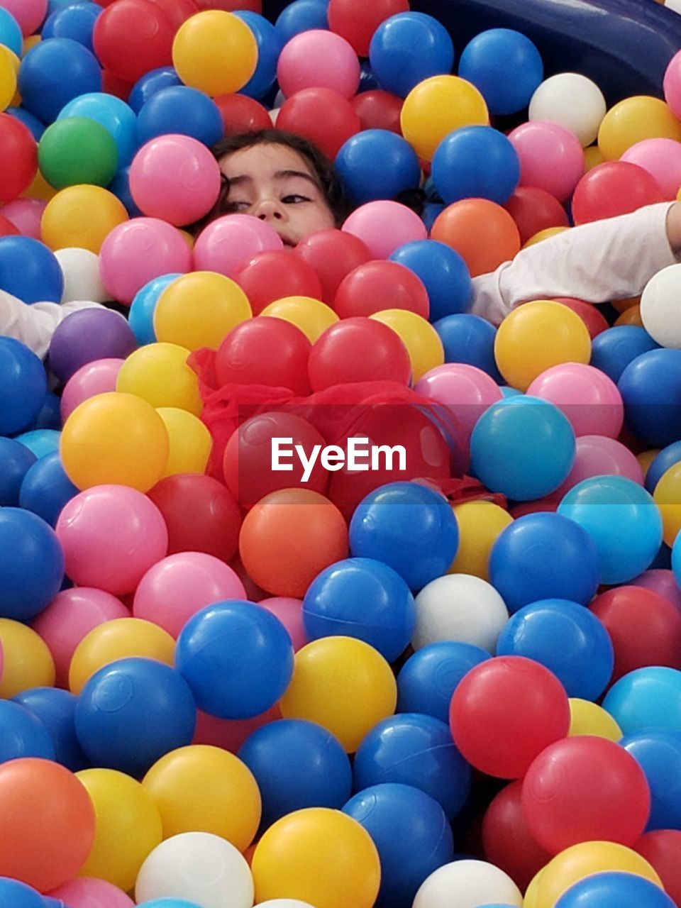 High angle view of cute girl in multi colored balls