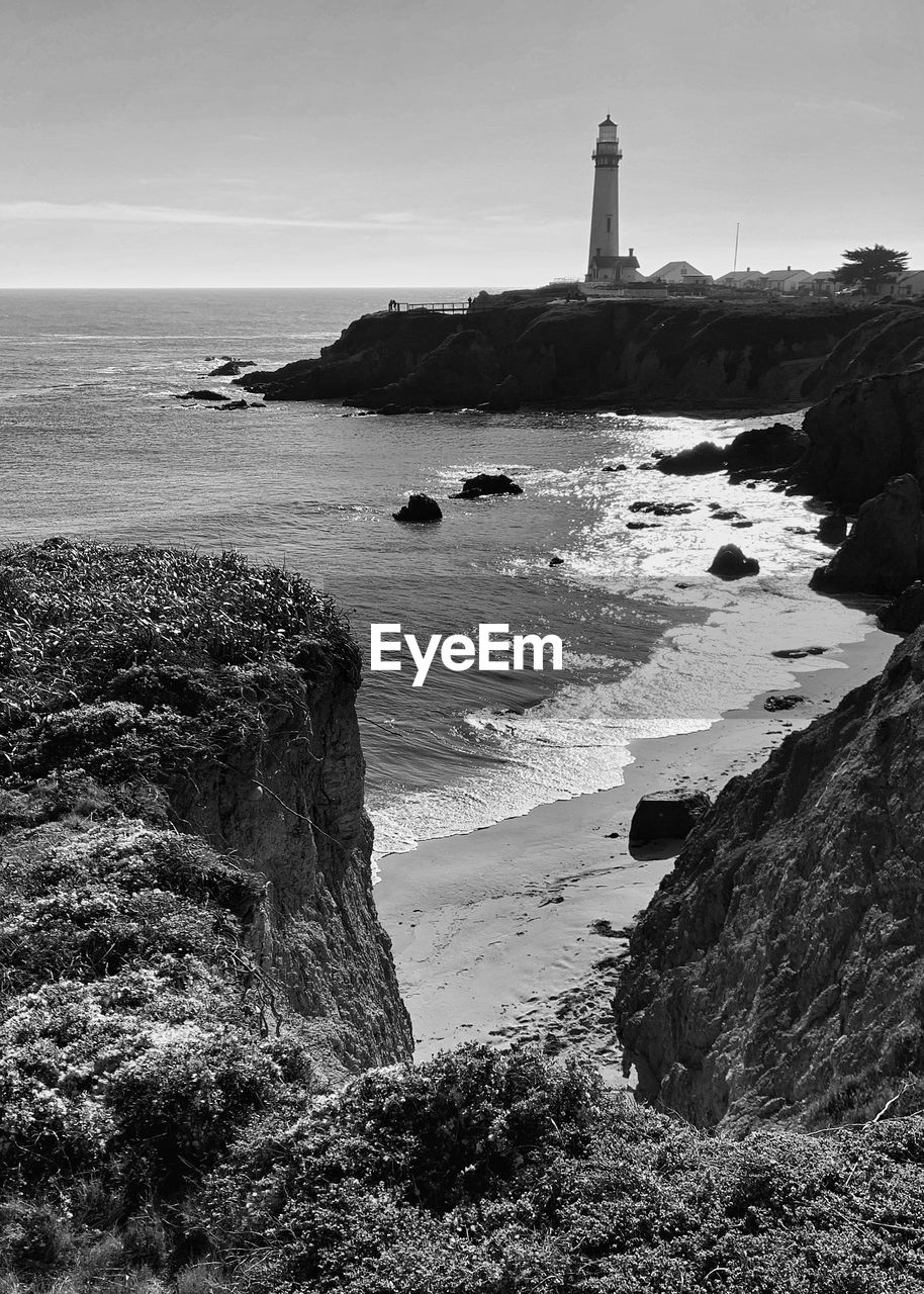 Black and white landscape of pigeon point lighthouse with ocean and rocky coast in foreground