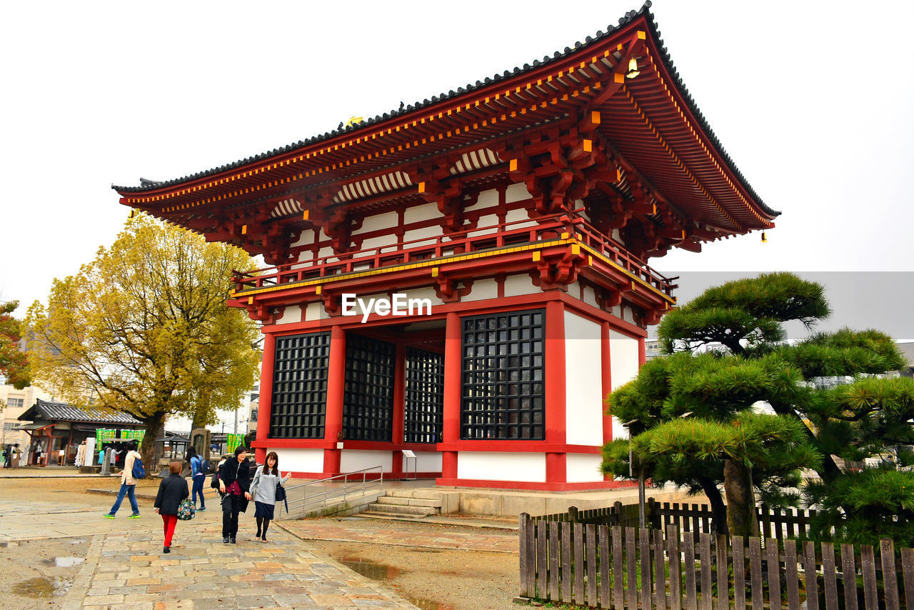 GROUP OF PEOPLE OUTSIDE TEMPLE BUILDING