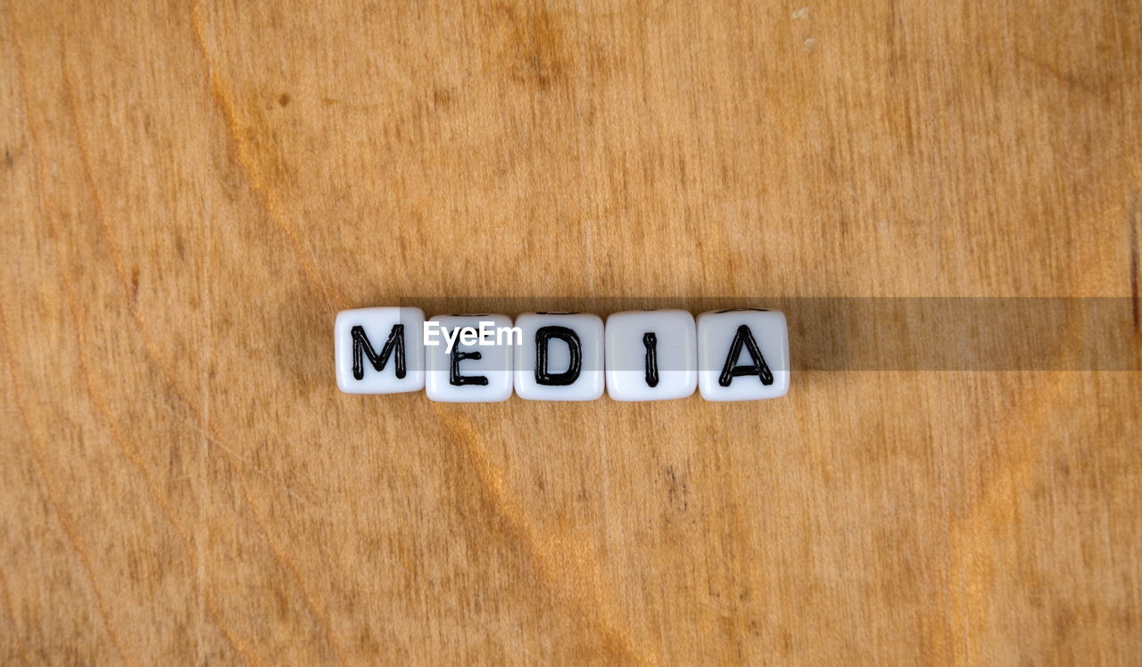 CLOSE-UP OF TEXT WRITTEN ON WOODEN TABLE