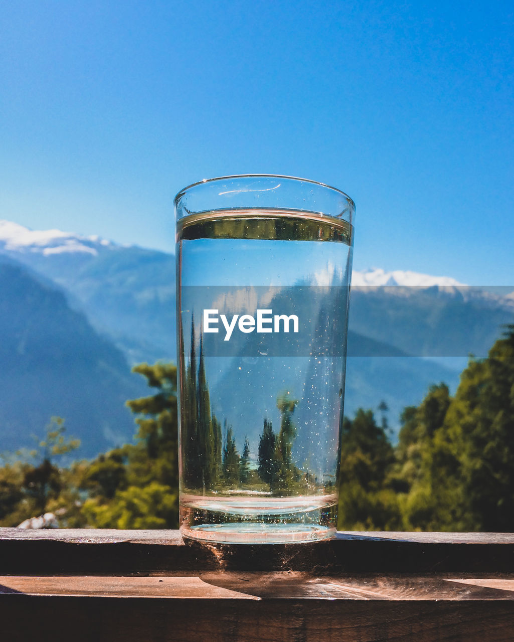 Close-up of glass of water against mountain