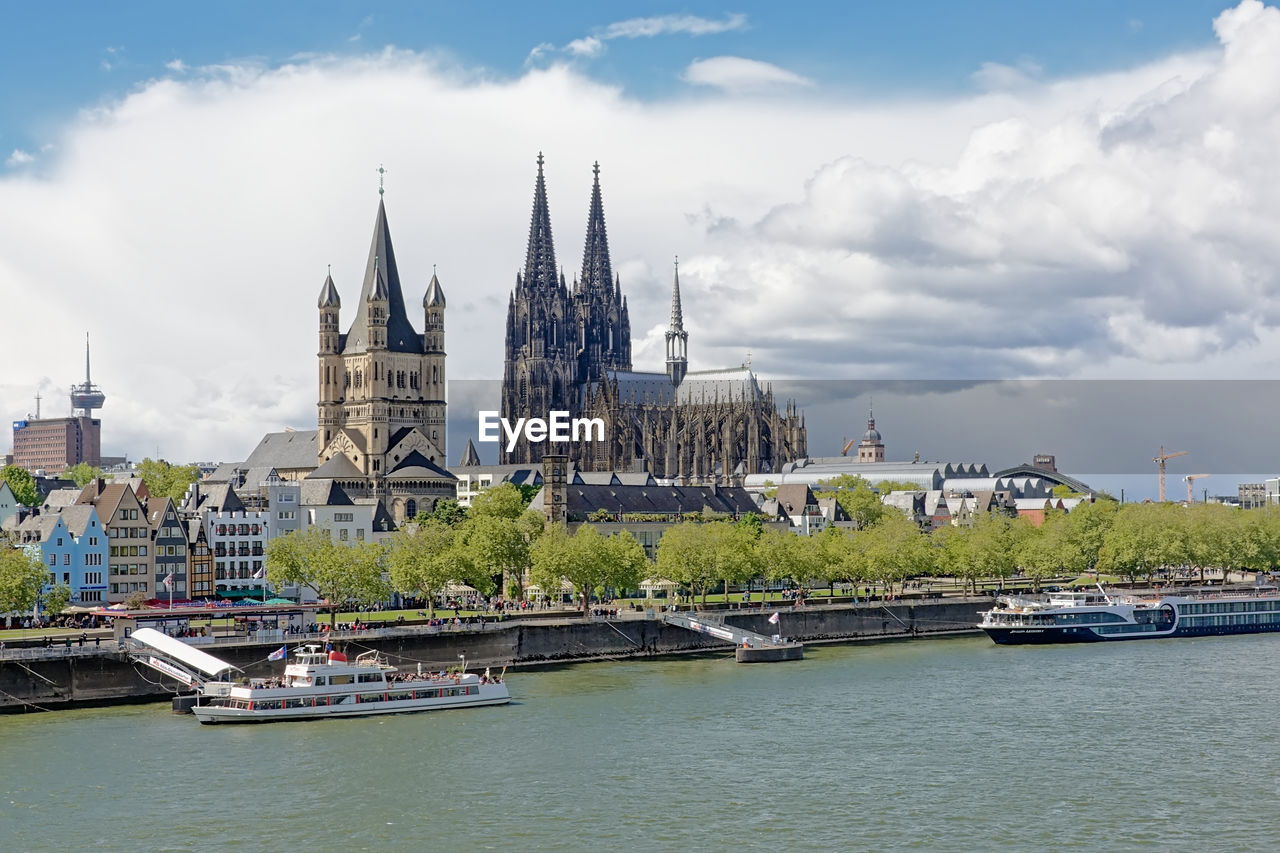 RIVER AMIDST BUILDINGS AGAINST SKY